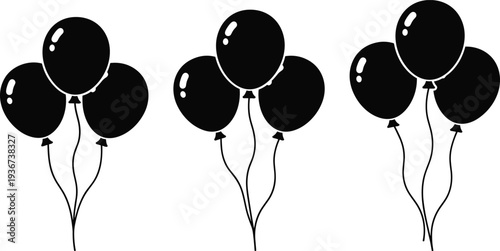 Groups of glossy black balloons tied together in sets of four, symbolizing celebration, party decoration, festive event, birthday, gathering, and entertainment concepts.