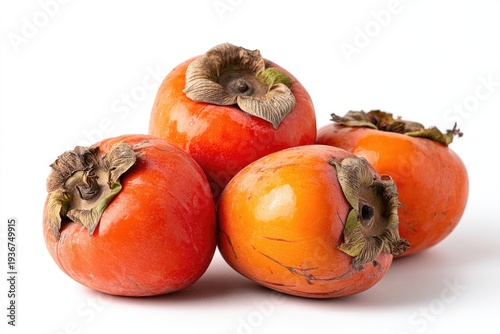 Four vibrant orange fruits with leafy tops, on a clean white backdrop