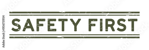 A distressed olive green safety first sign with horizontal lines above and below