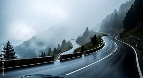 Winding mountain road through a misty forest, showcasing a dramatic and atmospheric scene of a wet highway curving through lush evergreen trees and shrouded hillsides.