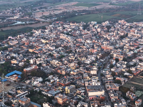 Aerial view of a densely populated rural town in india surrounded by green agricultural fields