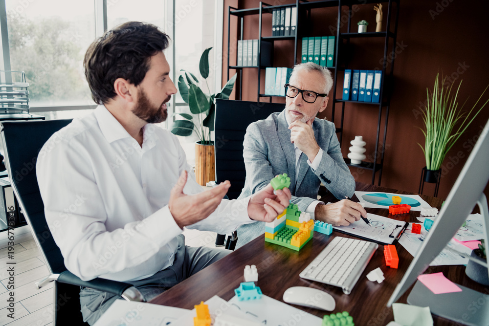 Fototapeta premium Business meeting in modern office two colleagues discuss strategy with colorful blocks and documents