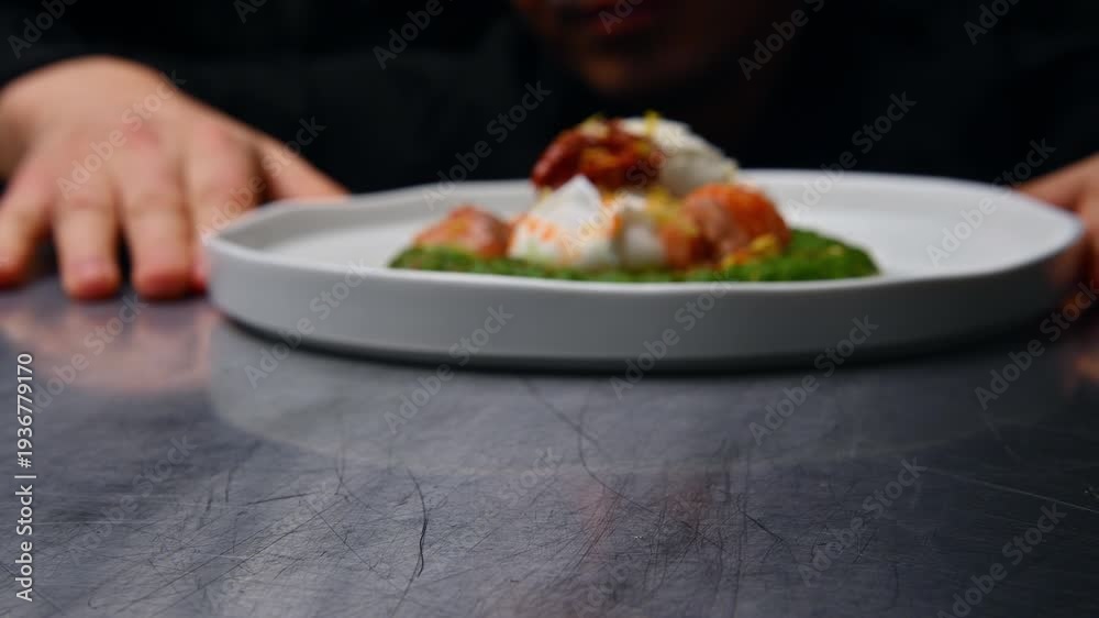 custom made wallpaper toronto digitalChef presenting a beautifully plated dish featuring poached eggs on a vibrant green sauce with garnishes, captured in a close-up view on a polished metal surface