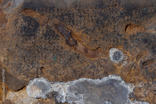 Detailed close-up of weathered sandstone showing rust streaks,  mineral crust...