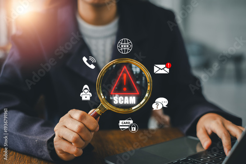 A person examines online scam alerts using a magnifying glass, highlighting digital security icons on a laptop.