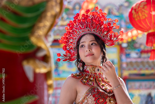 Young woman traditional red and gold costume with elaborate headdress smiling gracefully during cultural festival celebrationHappy Chinese New Year