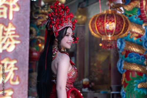 Tablou pe pânză Young woman in traditional red costume and elaborate headdress smiling in colorf