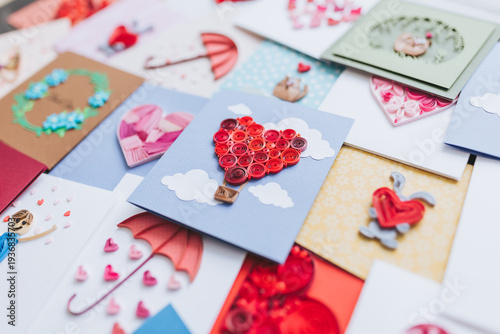 A vibrant collection of handmade cards is ready to celebrate special occasions like anniversaries and birthdays. Hand made of paper quilling technique. Handicraft at home. Hobby, home office. 