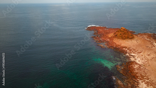 Bilde på lerret Aerial red rocky coastline with turquoise shallows