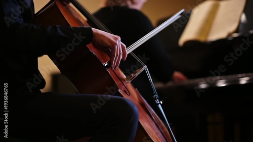 Cello player performing in a duet with a pianist during a classical concert.
