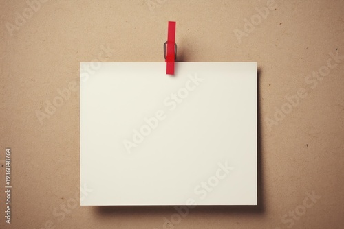 Blank white paper card held by a red clip on a brown notice board