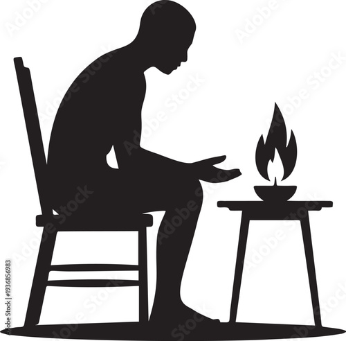 Person sitting on chair looking at a lit candle on small table