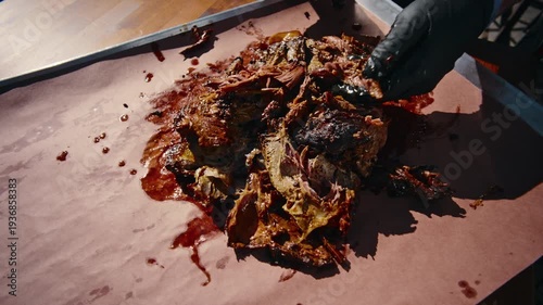 Top-down overhead view of thick smoked beef short ribs cut into sections on a wooden cutting board with a knife alongside in bright light