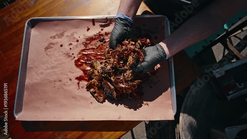 Full BBQ platter featuring brisket slices ribs sausage pickles red onion and sauce cup served on butcher paper on a wooden table
