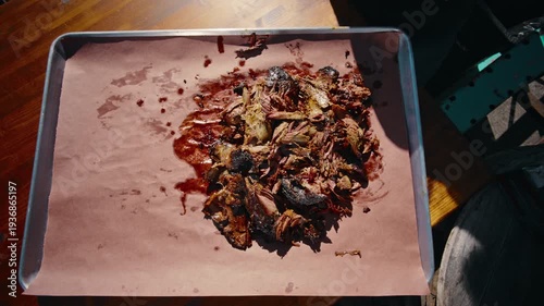 Side-angle close-up of thick smoked beef short ribs stacked on a wooden cutting board showing the rich bark exterior and juicy meat interior