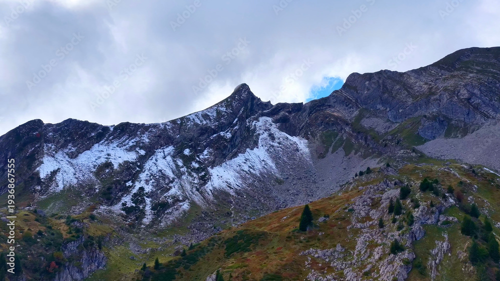 Fototapeta premium 4K Drone View Alpine Peak With Snow And Rocky Slopes