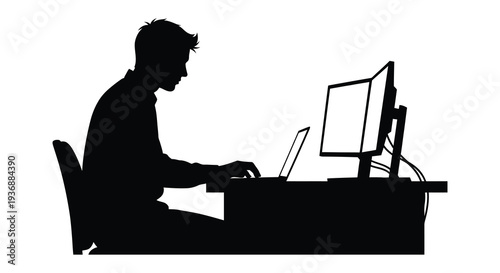 A silhouetted man is focused on working at a desk with a computer and laptop