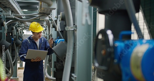 Bilde på lerret Professional industrial technician is inspecting pipeline valves with a laptop in a modern mechanical plant, focusing on digital transformation and operational efficiency