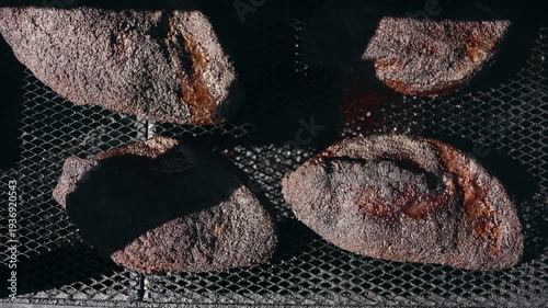 Top down shot of briskets sitting on the grate of a smoker