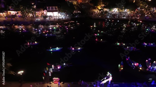 Traditional boats with colorful lanterns sailing on the thu bon river during a festival at night in hoi an, vietnam