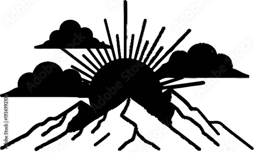 Sunburst rising over jagged mountains through clouds
