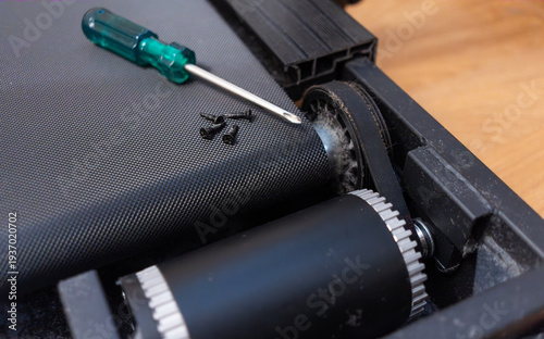 Repair and prevention of a treadmill.Replacing parts in a broken treadmill.The motor drive belt in the simulator.A screwdriver with screws.