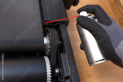 Service repair of the treadmill.Greasing the treadmill.Maintenance of exercise equipment.A cylinder with grease.