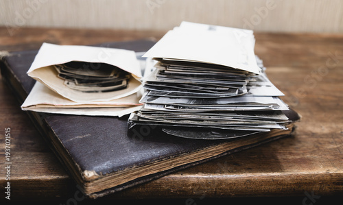 Old letters with documents are lying on a wooden table.A photo of a vintage-style desktop.Family photo archive.