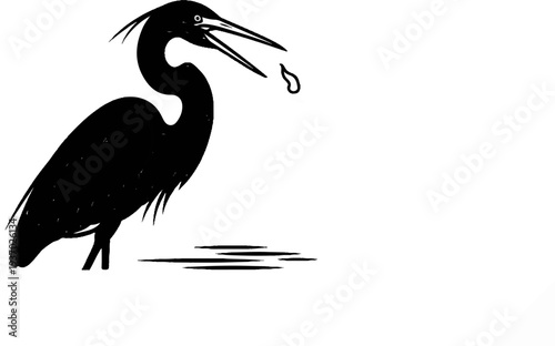 Silhouette of a heron standing in water, catching a drop