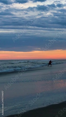 Silhouette of Men Fishing from Sandy Beach at Evening Sunset a Summer Day