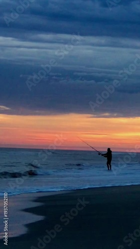 Fisherman Casting Line into Ocean at Colorful Beach Sunset