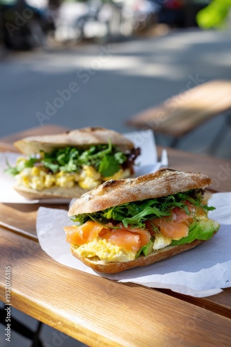Fresh gourmet sandwiches with salmon and vegetables on rustic bread