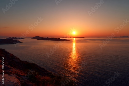A mesmerizing sunset view over the ocean with the sun reflecting on the water, highlighting the islands in silhouette 