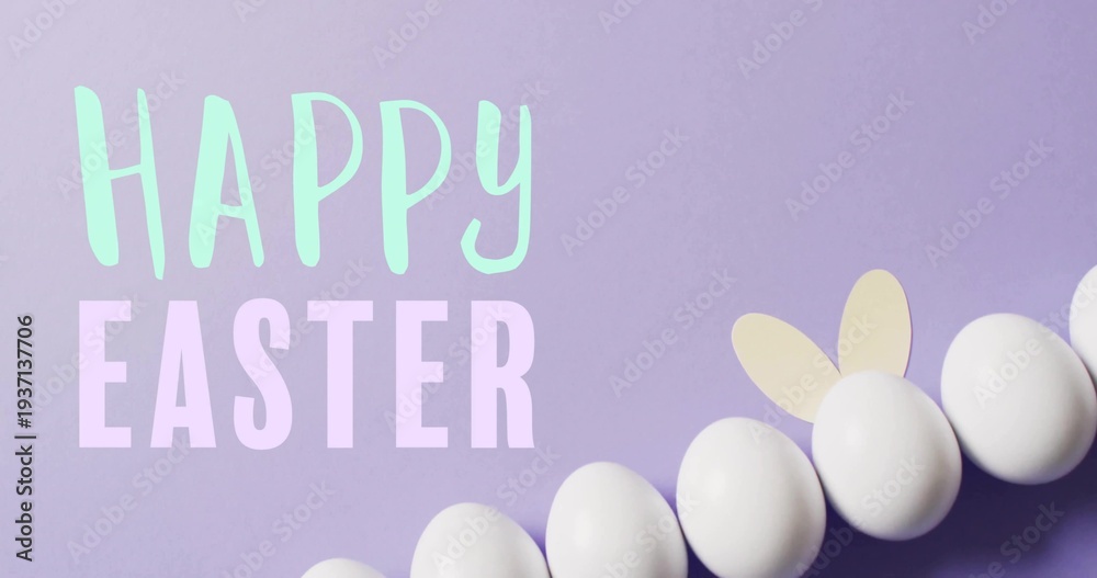 Fototapeta premium Displaying white eggs with bunny ears on pastel lavender flat-lay, showing HAPPY EASTER letters