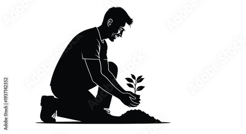 Man kneeling to plant a small tree a striking black silhouette