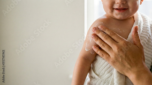 Mother applying body lotion baby skin care copy space hygiene moisturizing cream massage parenting love tenderness family routine bathroom close up portrait soft touch newborn health