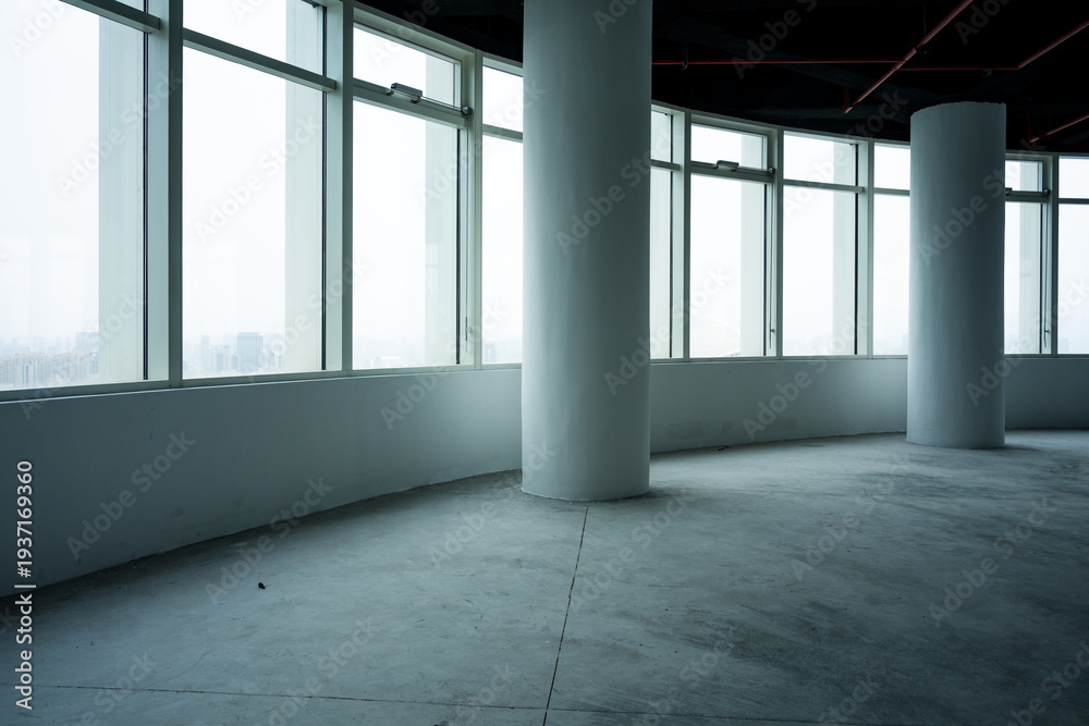Fototapeta premium Empty modern office space with floor-to-ceiling windows and concrete columns