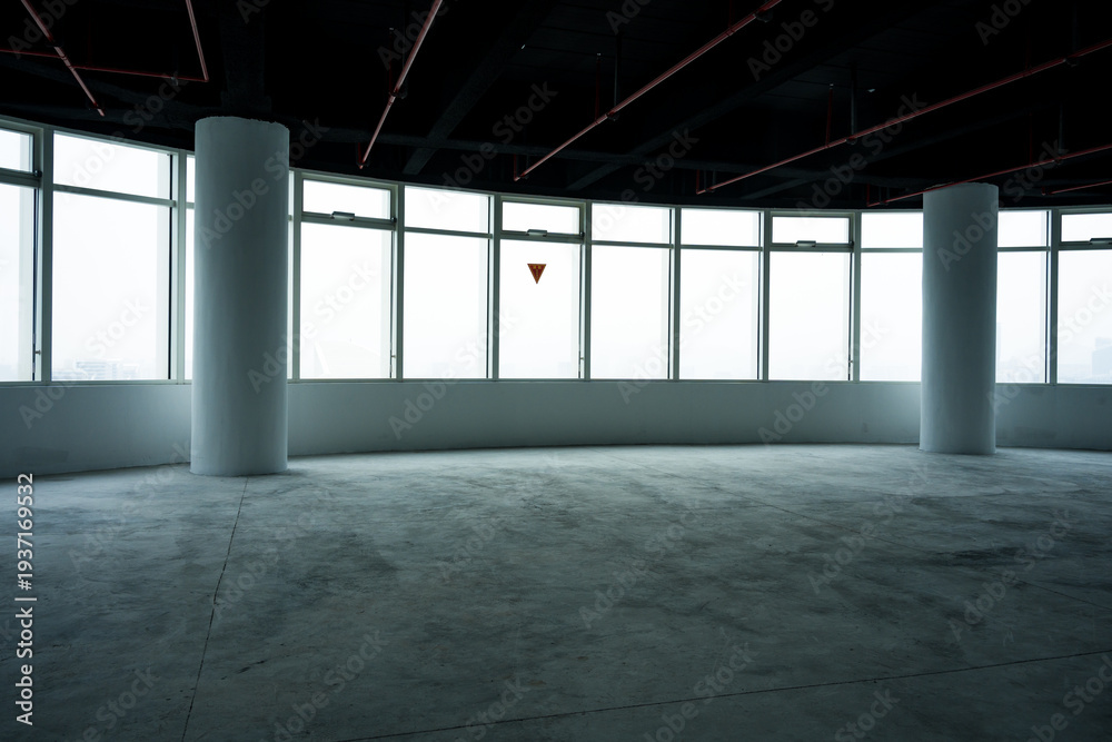 Fototapeta premium Empty modern office interior with panoramic floor-to-ceiling windows and concrete columns