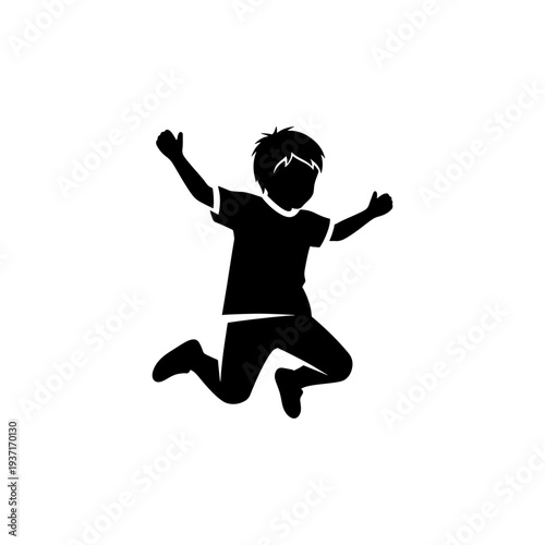 A joyful young boy is captured mid jump arms raised in playful exuberance silhouette