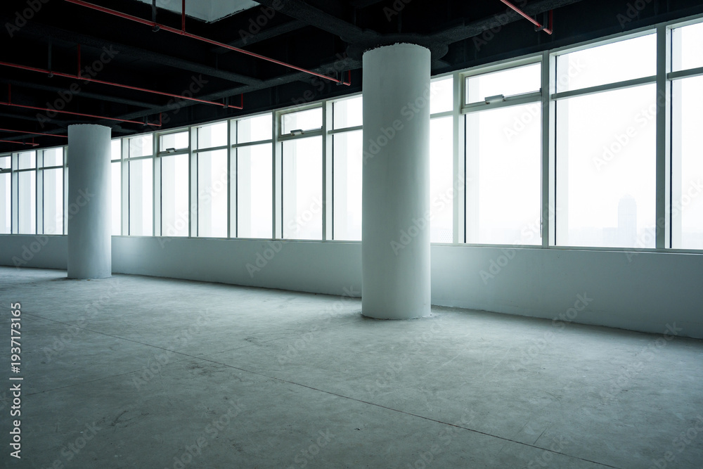 Fototapeta premium Spacious office interior with white columns and large floor-to-ceiling windows