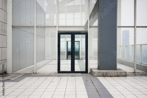 Modern architectural glass corridor with empty walkway and geometric structural elements