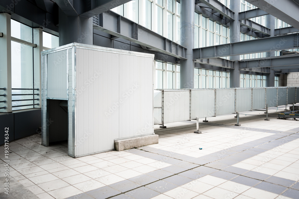 Obraz premium White temporary partition and barrier inside industrial factory with steel framework and tiled floor