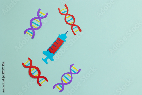 Syringe next to DNA structures on a light blue background with copy space. Concept of biomedical research, genetics, pharmaceutical innovation, and advances in health, made in paper art