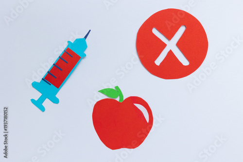 Apple next to a syringe and a rejection symbol inside a red circle on a white background. Concept of rejecting chemicals in food, pesticides, and concern about food safety, made in paper art