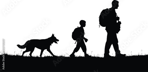 Silhouette of man and boy walking with dog on grass