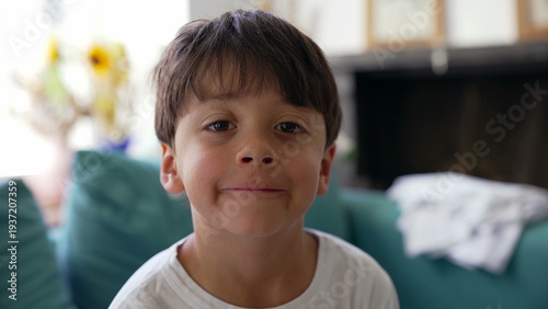 Obraz na plátně Young boy smirking playfully at camera, confident expression, cheeky smile, chil