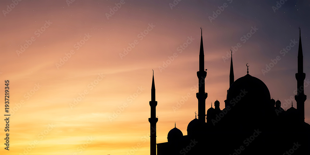 Fototapeta premium Silhouette of a mosque with minarets at sunset or sunrise with orange sky