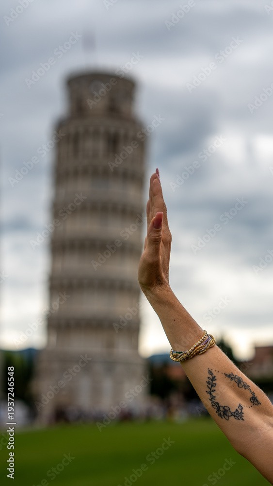 Fototapeta premium University graduate under the Leaning Tower in Pisa with laurel crown striking iconic pose