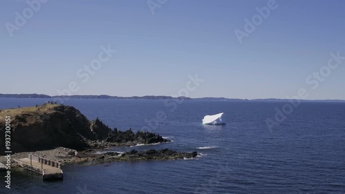 Tourist viewing an iceberg near shore, Newfoundland and Labrador, Canada. 
