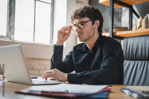 Foto Worried, accountant and man with laptop in office, employee and mistake on financial report and web